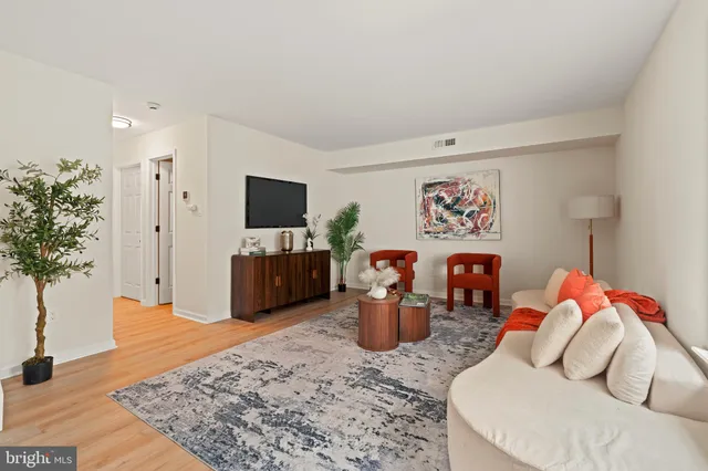 a living room with furniture and a potted plant