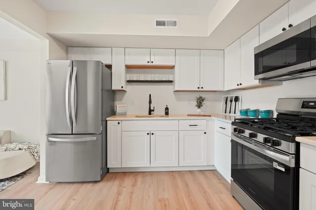 a kitchen with a refrigerator stove and white cabinets