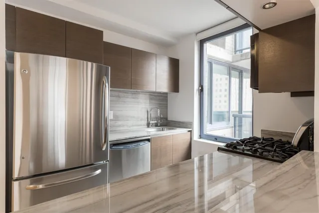 a kitchen with stainless steel appliances a refrigerator sink and cabinets