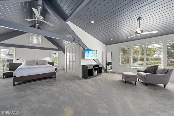 a spacious bedroom with bed and balcony
