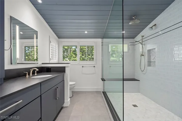 a bathroom with a double vanity sink and mirror with bathtub
