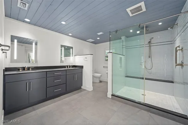 a spacious bathroom with a shower sink and mirror