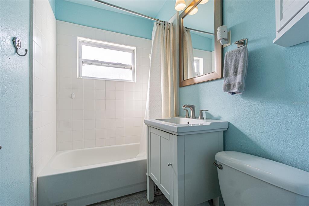 9696 Groveland Street Seminole, FL 33772 - Photo 12 of 22 a bathroom with a granite countertop toilet a sink and a bathtub