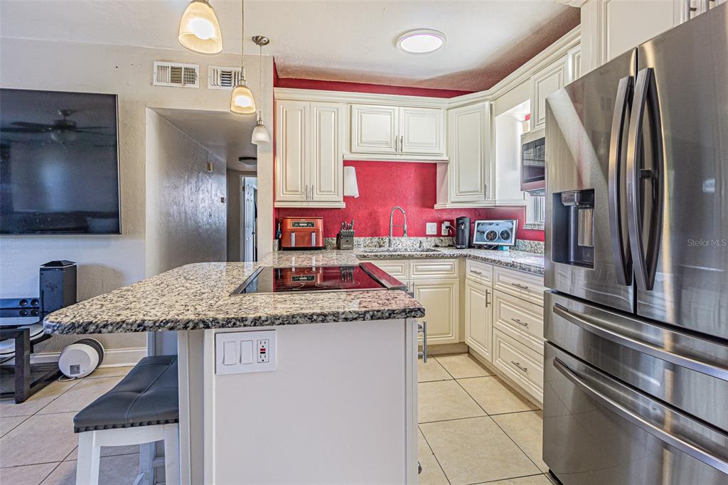 9696 Groveland Street Seminole, FL 33772 - Photo 6 of 22 a kitchen with stainless steel appliances granite countertop a sink stove and refrigerator