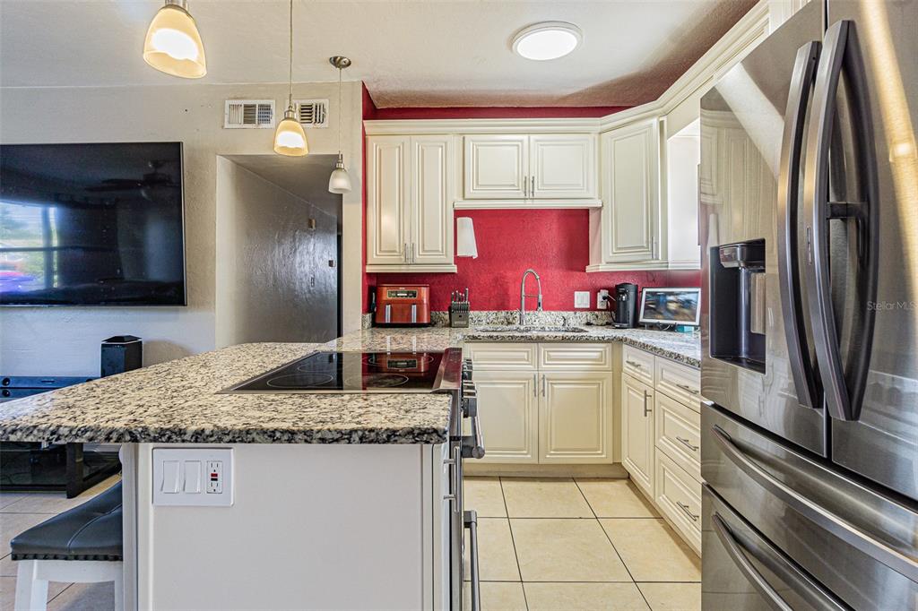 9696 Groveland Street Seminole, FL 33772 - Photo 7 of 22 a kitchen with stainless steel appliances granite countertop a sink stove and refrigerator
