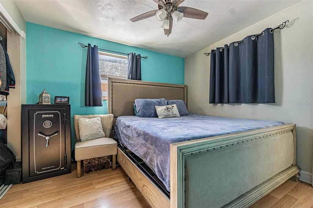 9696 Groveland Street Seminole, FL 33772 - Photo 9 of 22 a bedroom with a bed and a chandelier