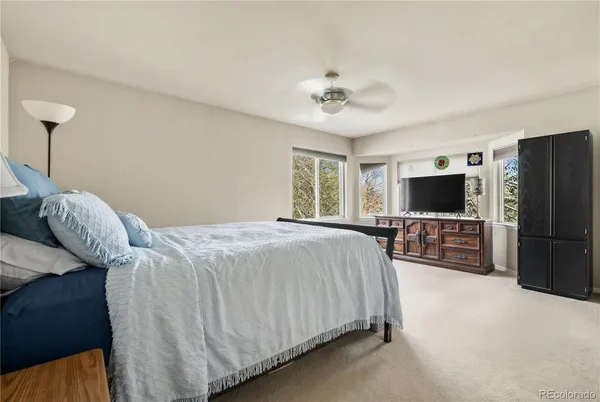a spacious bedroom with a bed and a flat screen tv
