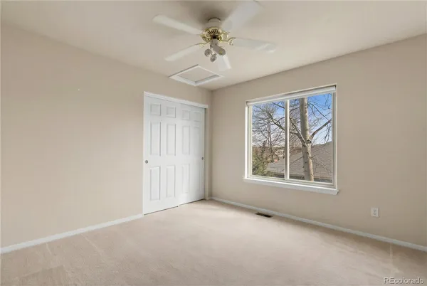 an empty room with windows and fan