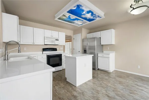 a kitchen with white cabinets and white appliances