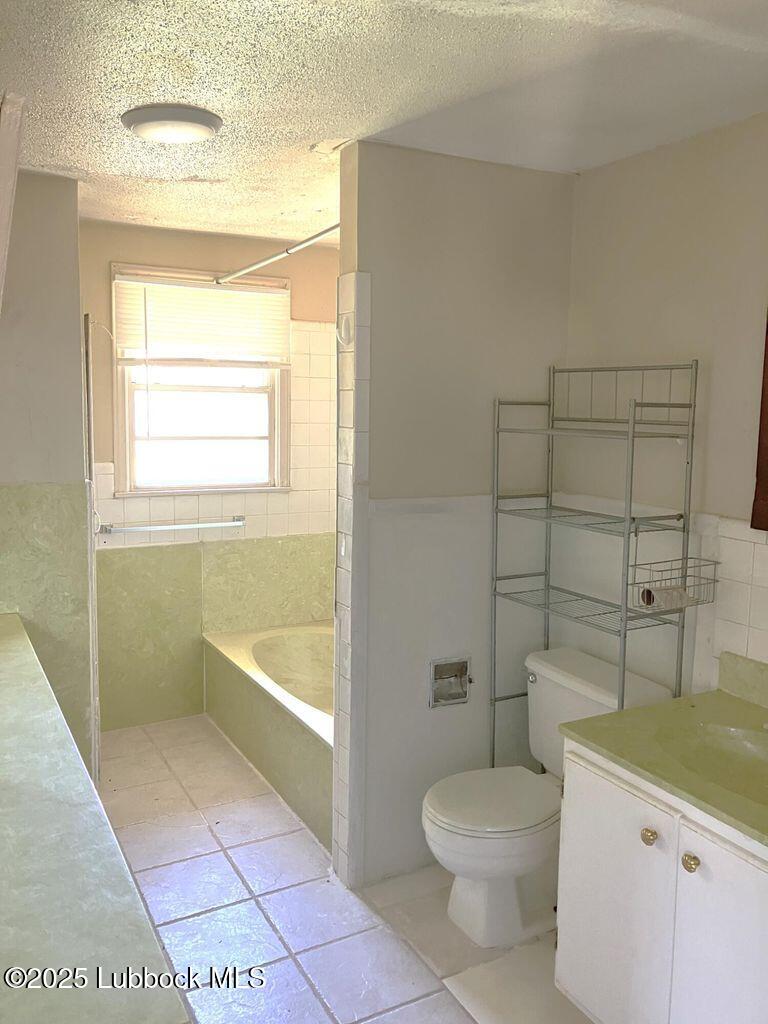 1615 Utica Plainview, TX 79072 - Photo 18 of 26 a bathroom with a granite countertop toilet a sink and a bathtub