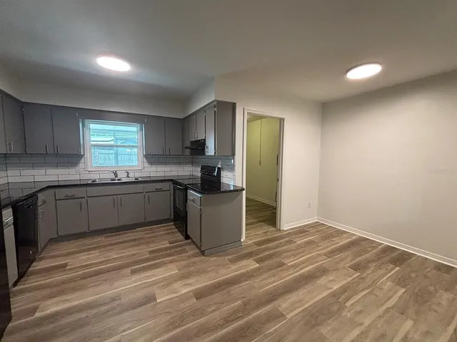 a kitchen with stainless steel appliances granite countertop a stove a sink and a refrigerator