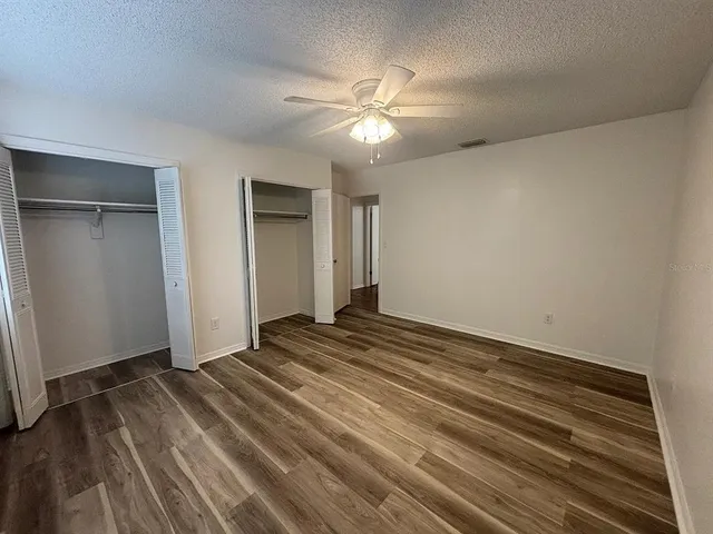 a view of a livingroom with wooden floor and a ceiling fan