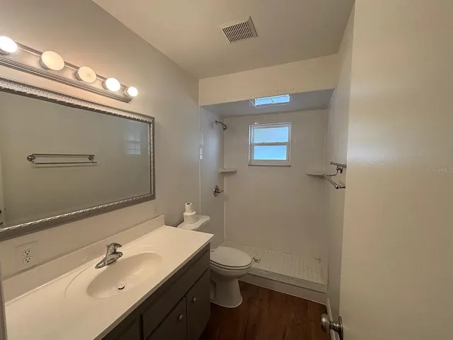 a bathroom with a sink a toilet and shower