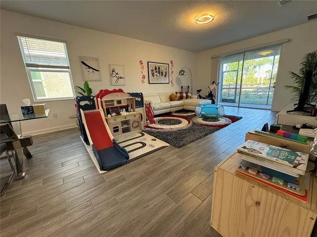 a living room with furniture a flat screen tv and a table