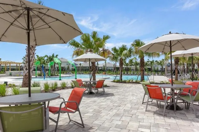a view of a tables and chairs under an umbrella in the patio