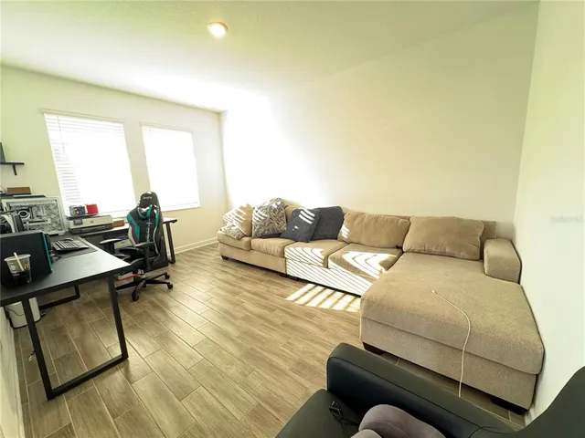 a living room with furniture and a wooden floor