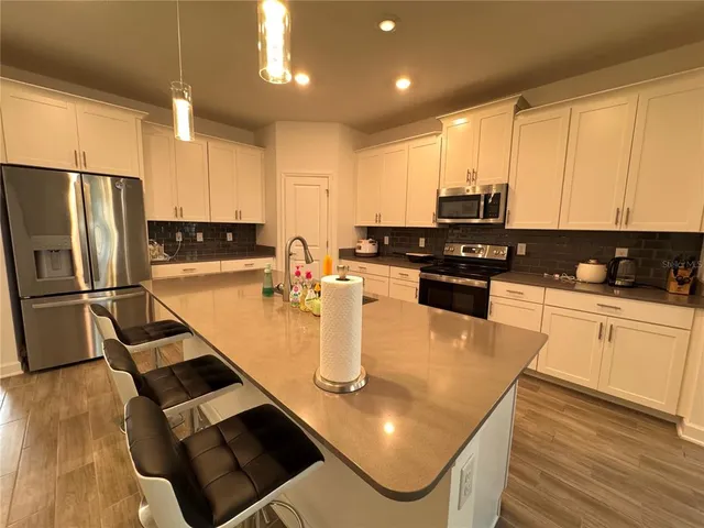 a kitchen with stainless steel appliances granite countertop a sink refrigerator and cabinets