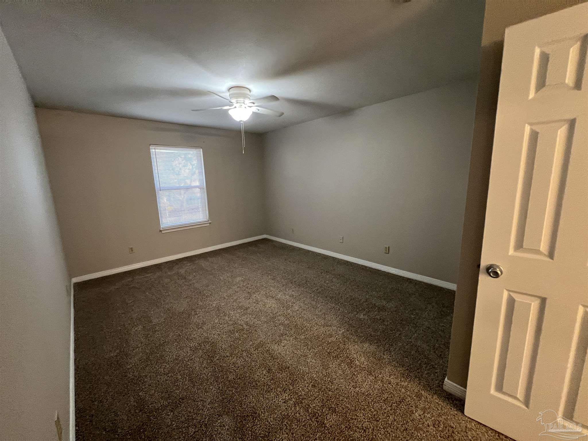 9485 Sunnehanna Boulevard Pensacola, FL 32514 - Photo 16 of 24 an empty room with windows and fan