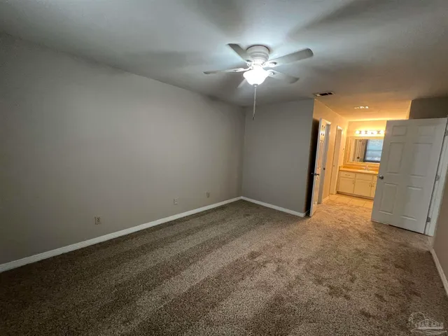 a view of an empty room with a chandelier fan