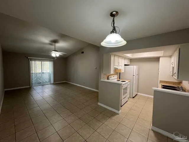 a kitchen with granite countertop white cabinets stainless steel appliances a sink and a window