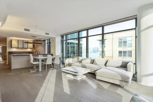 a living room with furniture and floor to ceiling windows