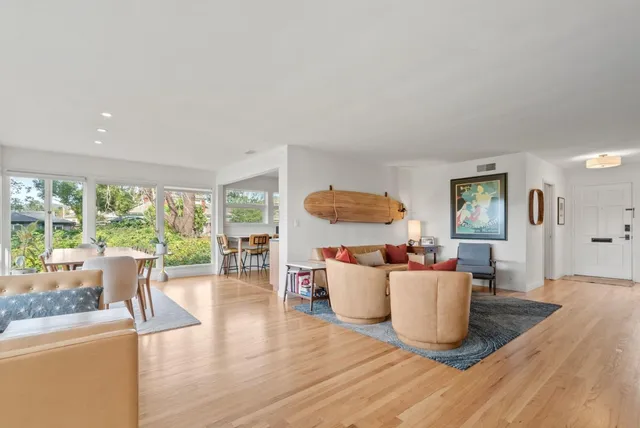a living room with furniture a large window and a dining table