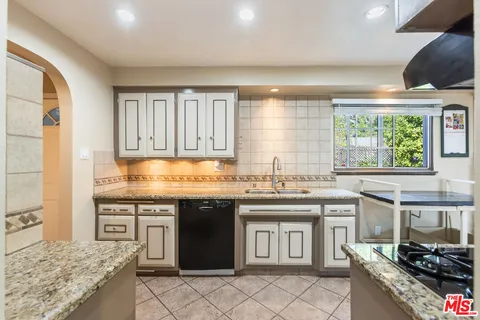 a kitchen with a sink stove and cabinets