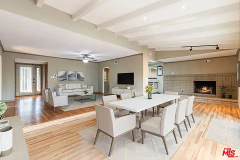 a view of a dining room with furniture wooden floor and a fireplace