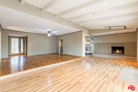 a view of empty room with wooden floor and fireplace