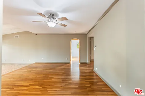 a view of empty room with wooden floor