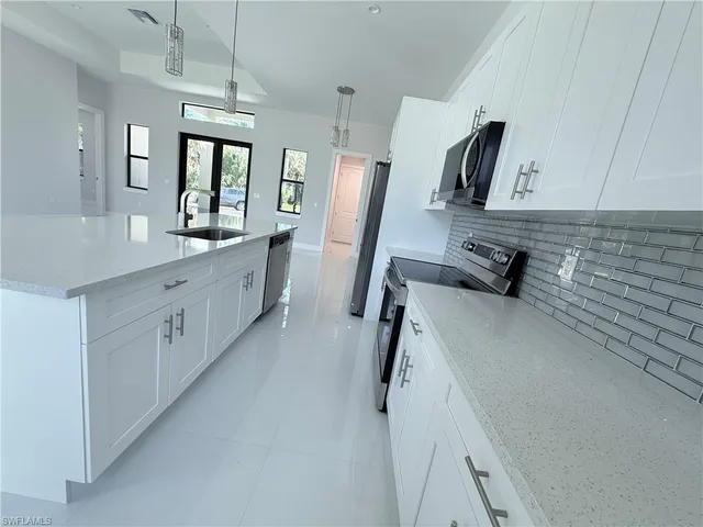 a kitchen with white cabinets and stainless steel appliances