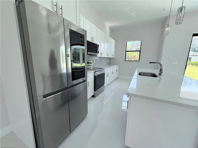 a kitchen with stainless steel appliances a sink stove and refrigerator
