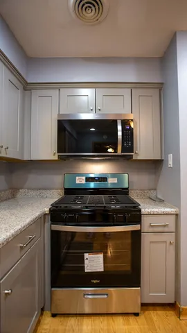 a kitchen with stainless steel appliances granite countertop a stove and a microwave