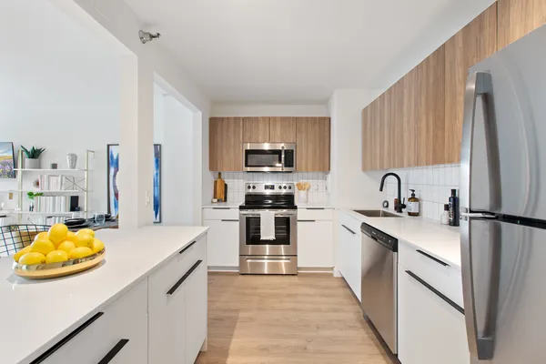 a kitchen with stainless steel appliances a stove a sink and a refrigerator