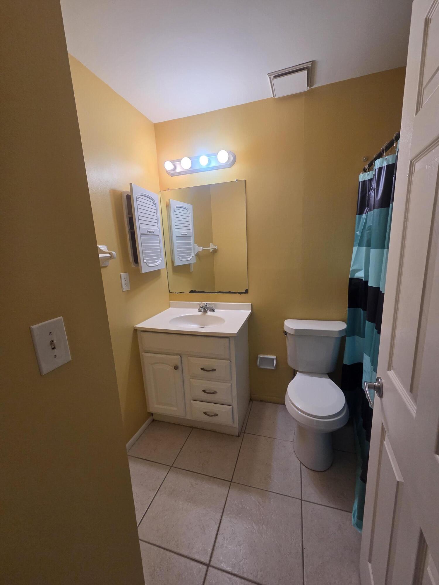 1917 Southeast Burgundy Lane Port St. Lucie, FL 34952 - Photo 12 of 13 a bathroom with a toilet sink and mirror