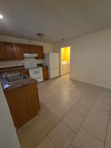 a view of kitchen and empty room with windows