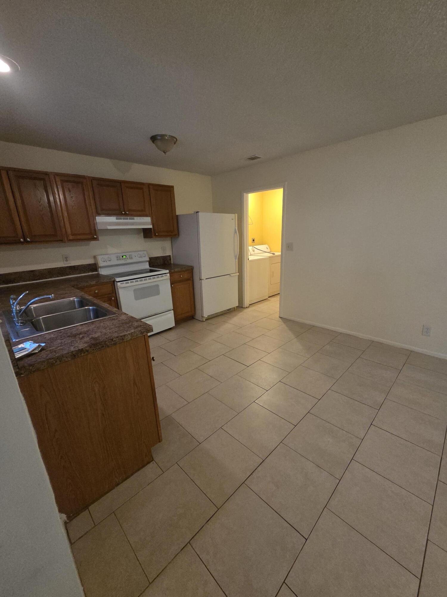 1917 Southeast Burgundy Lane Port St. Lucie, FL 34952 - Photo 3 of 13 a view of kitchen and empty room with windows