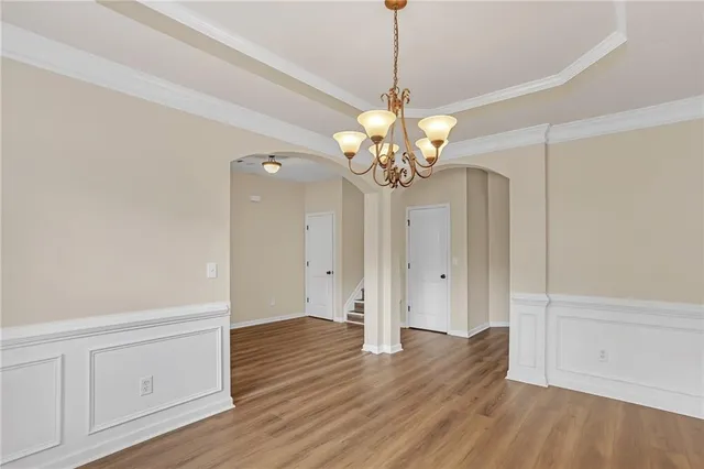 a view of a chandelier in big room with wooden floor