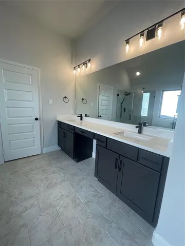 a spacious bathroom with a double vanity sink a mirror and a shower