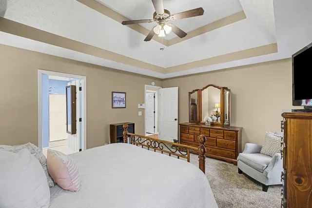 a bedroom with a bed a dresser and flat screen tv