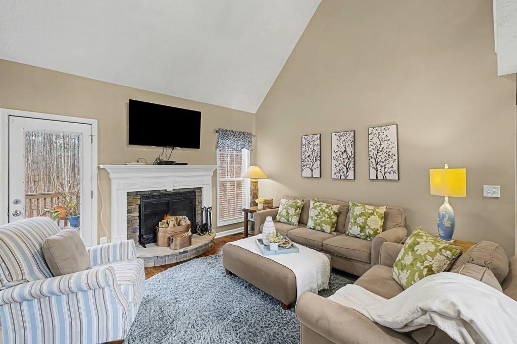 218 Amaranth Court Ball Ground, GA 30107 - Photo 10 of 46 a living room with furniture a fireplace and a flat screen tv