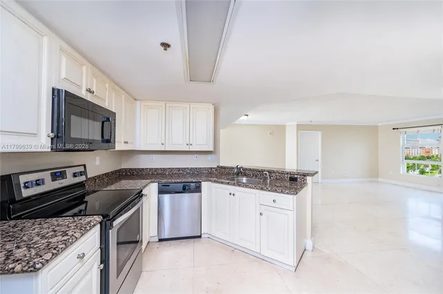 a kitchen with stainless steel appliances granite countertop a refrigerator stove and sink