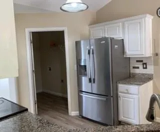 a kitchen with stainless steel appliances granite countertop a refrigerator and a sink