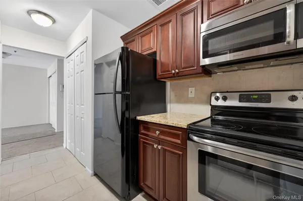 a kitchen with wooden cabinets and stainless steel appliances