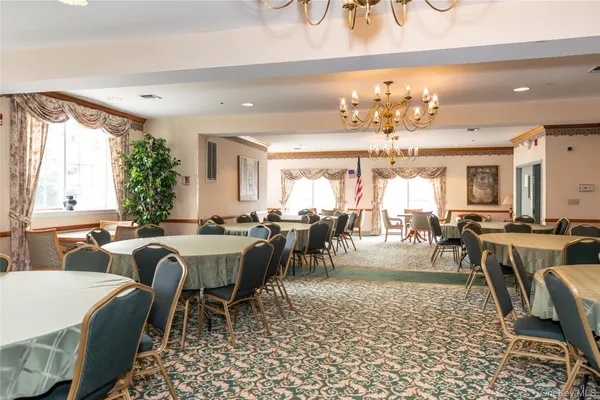 a large dining space with furniture a chandelier and window