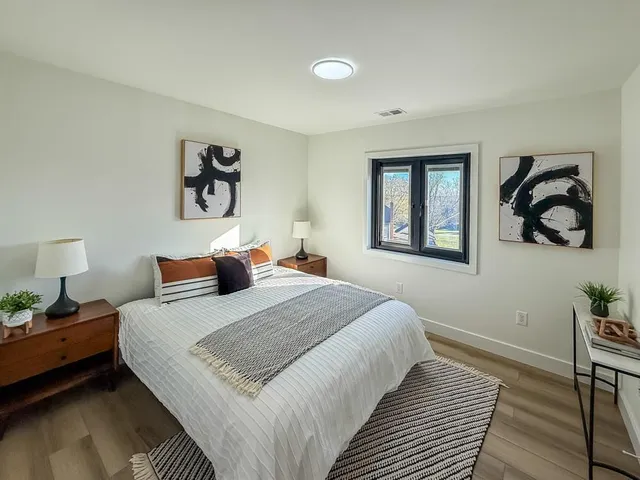 a bedroom with a bed and wooden floor