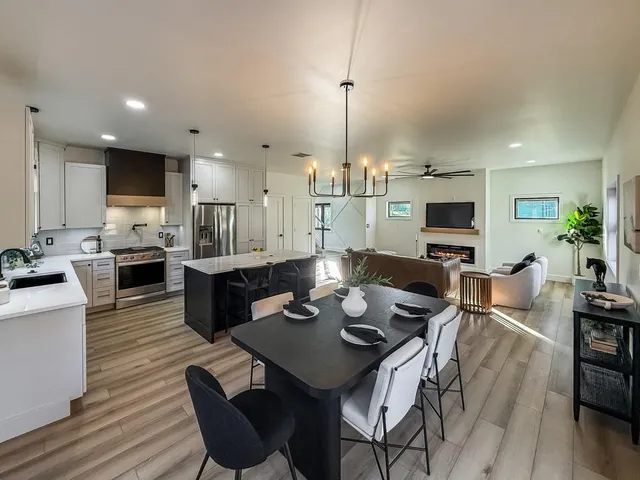 a view of a dining room with furniture a kitchen and chandelier