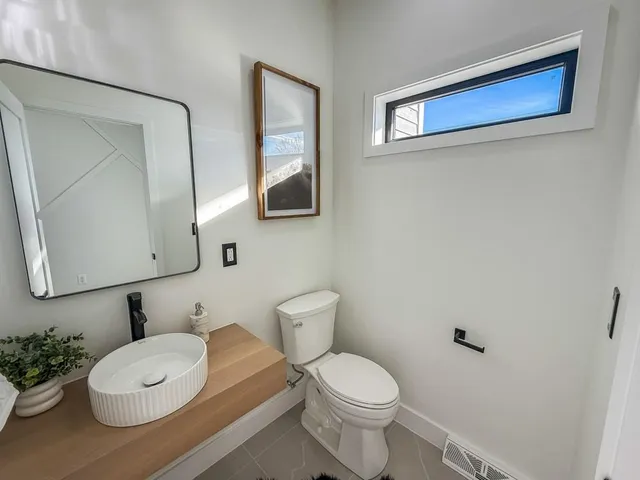 a bathroom with a toilet a sink and mirror