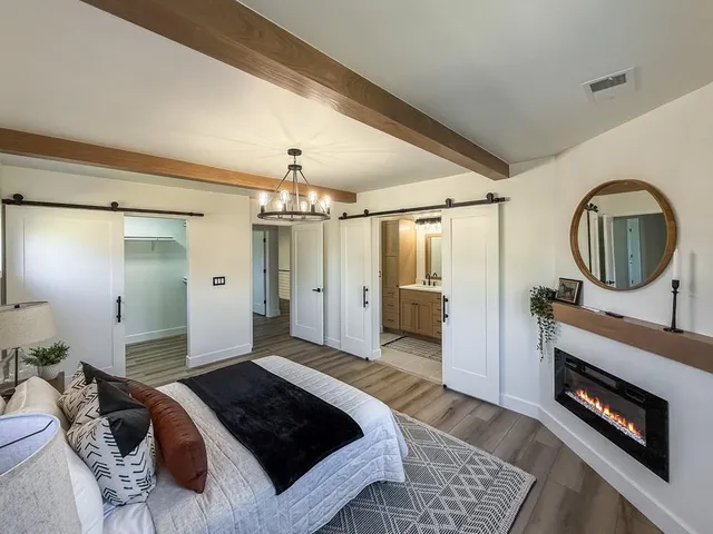 a bedroom with a bed a mirror and a chandelier