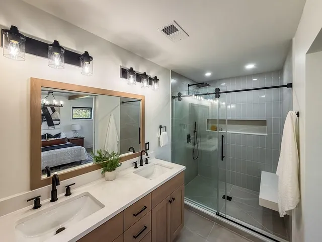 a bathroom with a shower sink and mirror